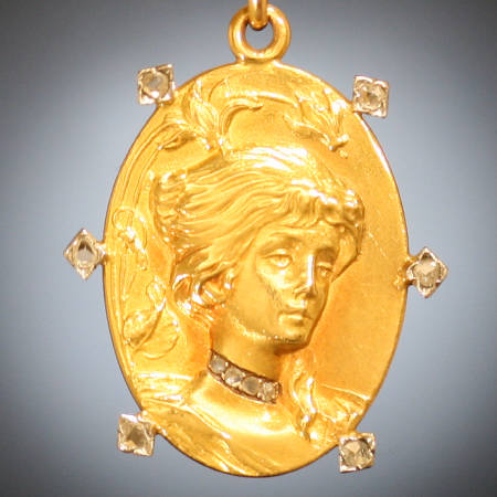 Art Nouveau woman's head golden pendant