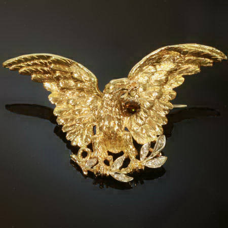 Estate brooch, eagle with spread wings holding a natural colored diamond in beak